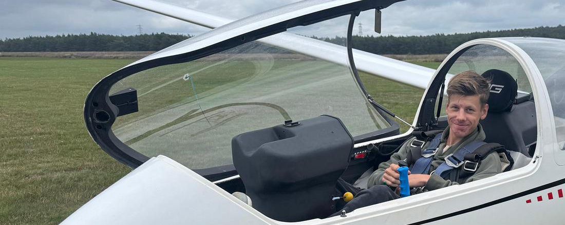 Een lid van ZC Flevo zit lachend in de cockpit van de DG-1000 van de club